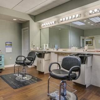 Interior view of an empty hair salon with chairs and mirrors.