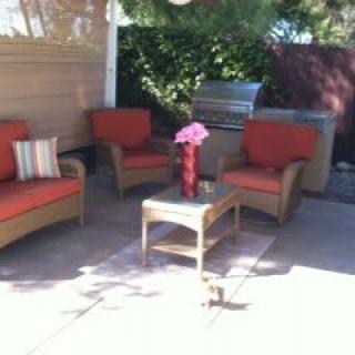 An inviting outdoor patio setup with comfortable seating and a central table adorned with flowers.