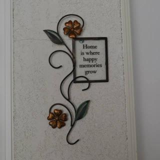 A decorative wall piece with floral design and an inspirational quote.