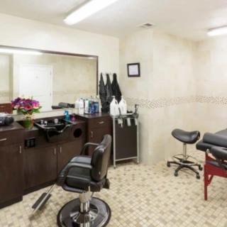 A cozy barber shop interior with a styling chair and mirror.