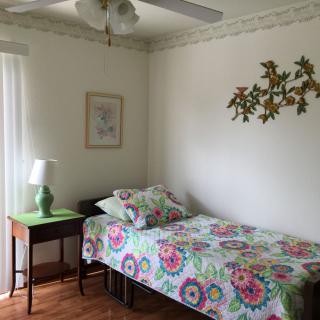 A cozy bedroom with floral bedding and simple decor.