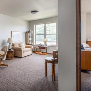 A cozy living room with a sofa, coffee table, and large window.