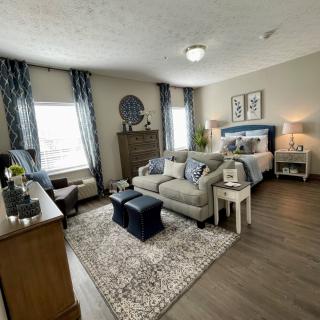 A spacious bedroom-living area combination featuring a sofa, bed, and elegant decor.