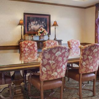 A cozy dining room with floral upholstered chairs and a decorative painting on the wall.