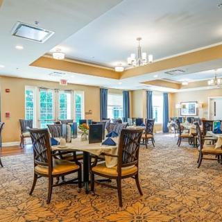 A spacious dining room with elegant furnishings and natural lighting.