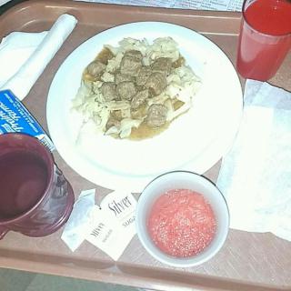 A hospital meal tray with beef stew, a red drink, and soup.