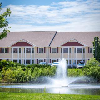 A serene hotel setting featuring a fountain surrounded by lush greenery.