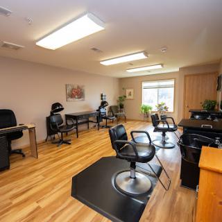 A spacious and well-lit salon with workstations and styling chairs.