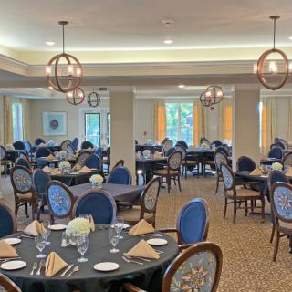 An elegant dining room with neatly arranged tables and chairs, set for a formal meal.
