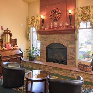 A cozy living room featuring a stone fireplace, elegant decor, and comfortable seating.