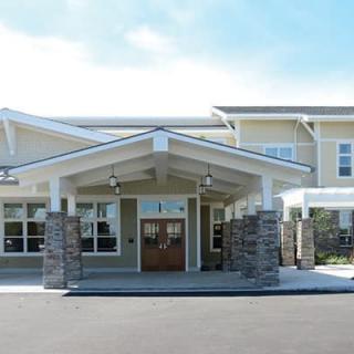 A modern building entrance with stone pillars and a peaked roof.