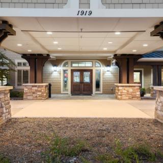 The illuminated entrance of a building with stone columns and decorative lighting.