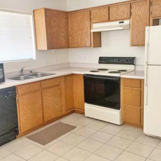 A simple kitchen with wooden cabinets and basic appliances.
