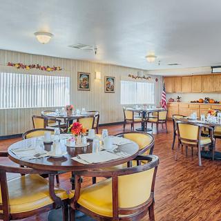 A cozy dining area with set tables and comfortable seating.