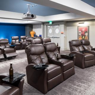 A stylish home theater with comfortable leather recliners and a projector setup for an immersive viewing experience.
