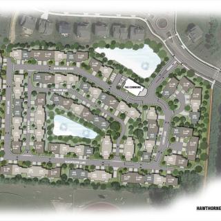 A detailed site plan of a residential housing development featuring roads, buildings, and landscaped areas.