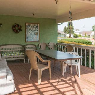 A cozy outdoor patio area with a table, chairs, and green walls.