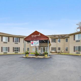 Exterior view of a hotel with a central entrance and parking area.