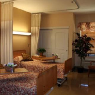 A hospital room with two beds separated by curtains.