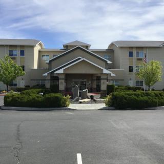 A view of the front entrance of a hotel with landscaped surroundings.