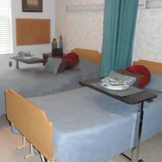 A hospital room featuring two beds with bedside tables, designed for patient comfort.