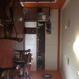 A kitchen and dining area featuring wooden cabinets, a dining table, and orange walls.