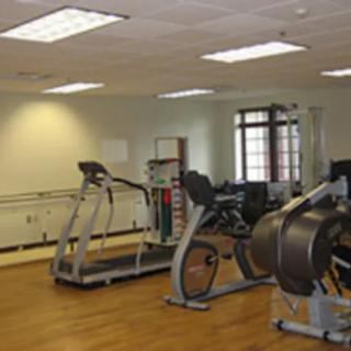 A small gym with various exercise machines including treadmills and stationary bikes.