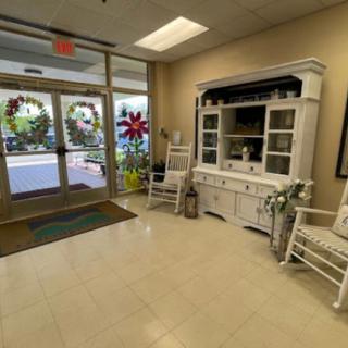 A cozy lobby area with rocking chairs and a decorative cabinet.