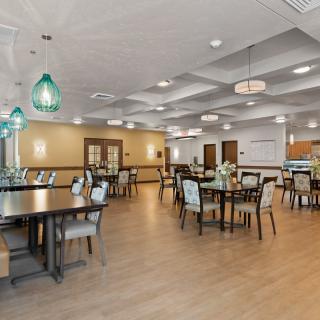 A spacious and well-lit dining area with neatly arranged tables and chairs.