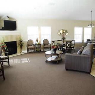 A spacious living room with a fireplace, comfortable seating, and a dining area.