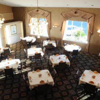 An elegant restaurant dining room with neatly arranged tables and large windows.