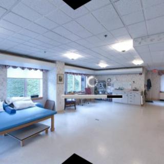 A clean and well-lit physical therapy treatment room with beds and equipment.