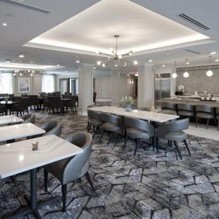 A modern restaurant interior featuring elegant seating and a stylish chandelier.