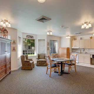 A cozy living space featuring a dining area and kitchenette with ample natural light.