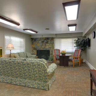 A cozy living room with comfortable seating, a fireplace, and natural lighting.