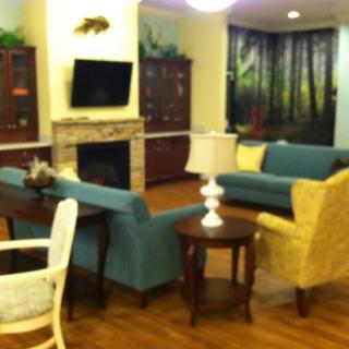 A cozy living room with sofas and a fireplace, featuring a television and elegant decor.