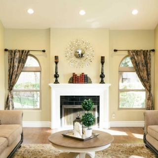 A cozy living room with a central fireplace, elegant decor, and comfortable seating.