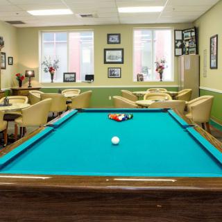 A cozy recreation room featuring a pool table and comfortable seating.