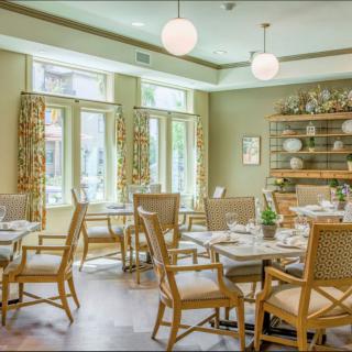 A bright and elegantly decorated restaurant dining area with neatly arranged tables and chairs.