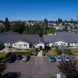 Aerial view of suburban housing with a parking lot in front.