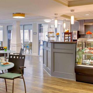 A modern cafe interior with a seating area and display case.