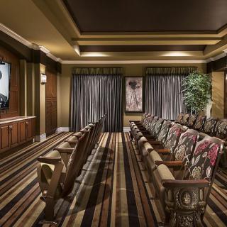 A luxurious home theater with elegant seating and a large screen.