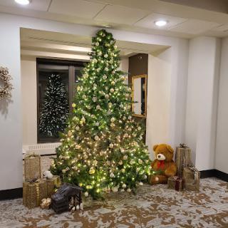 A beautifully decorated Christmas tree adorned with lights, surrounded by festive gifts.