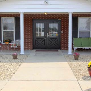 A welcoming entrance with a porch and flower pots, inviting visitors to step inside.