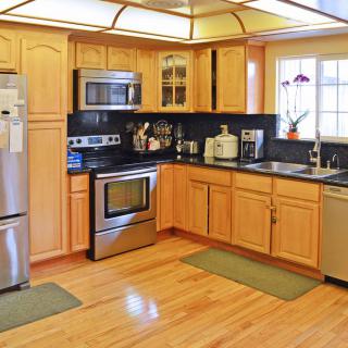 Modern kitchen with wooden cabinets and stainless steel appliances.