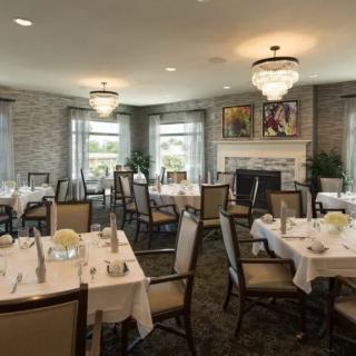 An elegant dining room with neatly arranged tables and chandeliers.