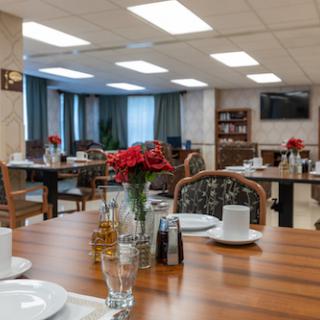 A beautifully arranged dining room featuring elegantly set tables with floral centerpieces.