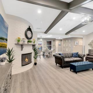 A spacious and modern living room with a fireplace and stylish furniture.