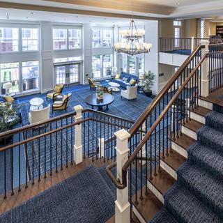 Spacious hotel lobby with elegant seating and a large chandelier.