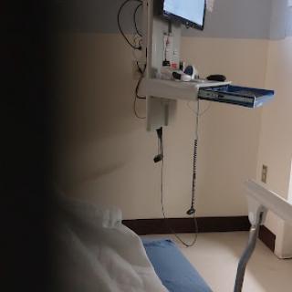 A view of a hospital room with medical equipment and a bed.